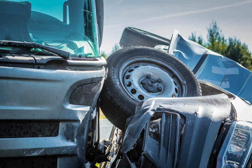 severe accident scene shows a large truck and a smaller vehicle in a violent collision