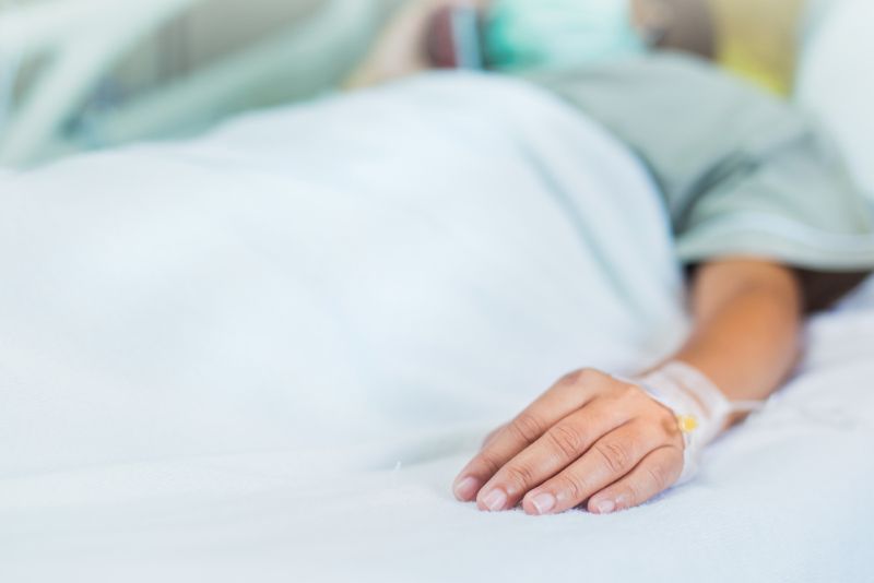 woman's hand laying in a hospital bed