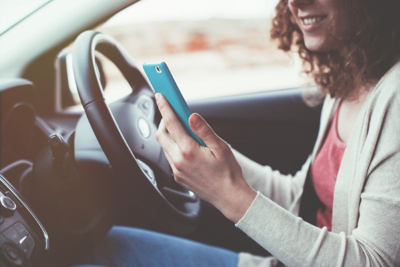 woman using phone while driving