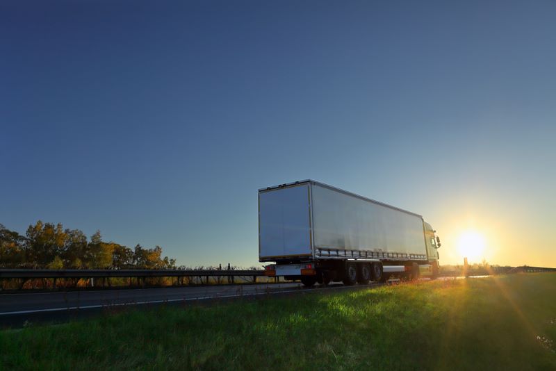 semi truck on highway at sunset