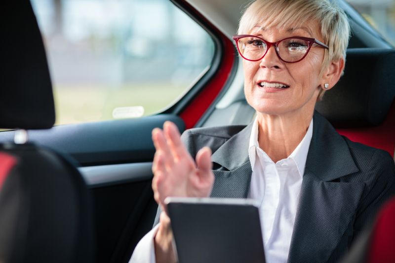 passenger in the back seat of a car talking to driver
