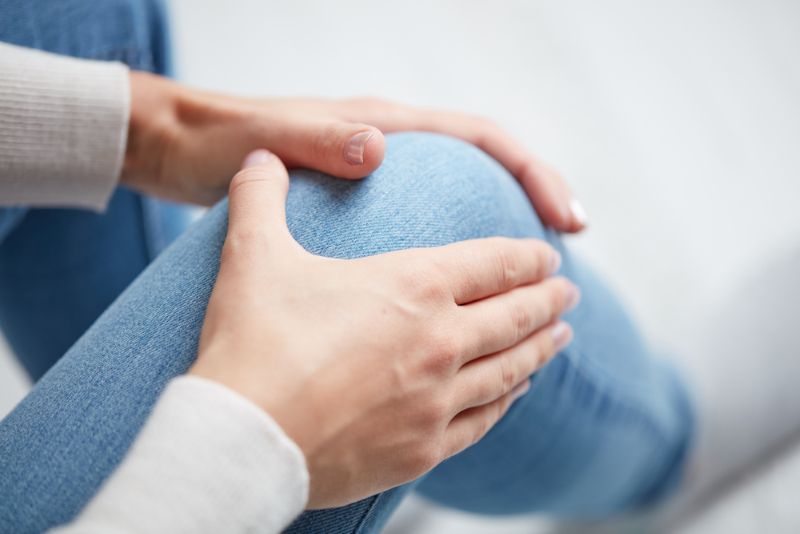 woman grabbing her knee in pain