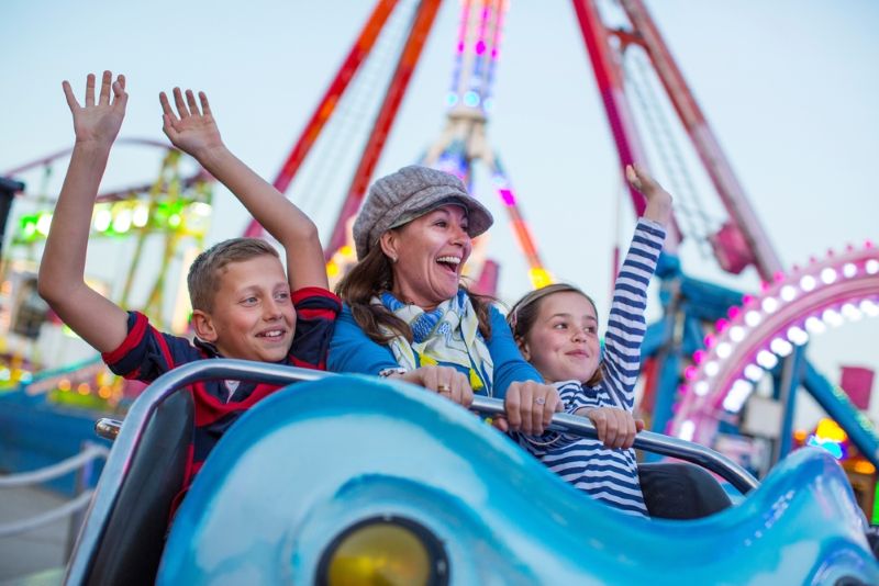 Mother on an amusement park ride with her two children