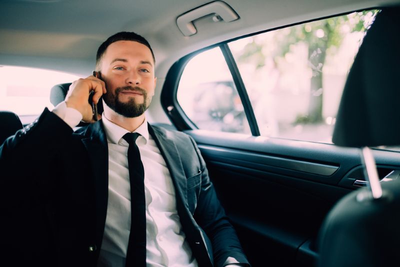 Businessman on his cell phone in the back seat of a car